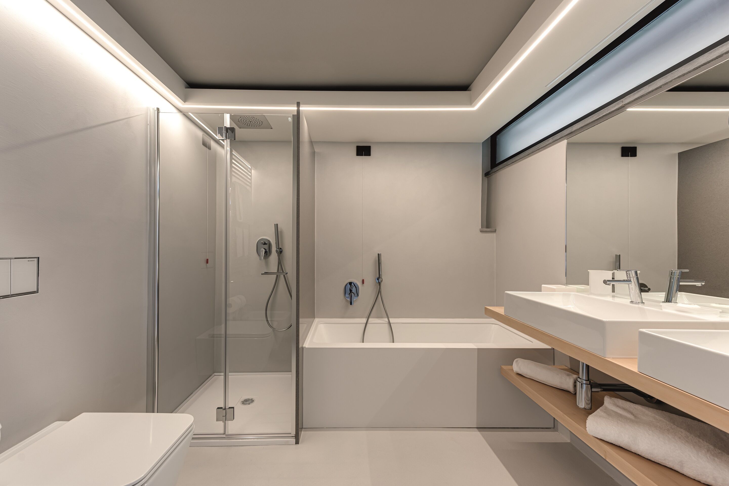 Une salle de bain moderne dotée d’une douche à parois de verre, d’une baignoire sur pieds et d’un meuble-lavabo avec un miroir.