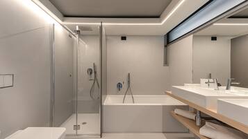 Une salle de bain moderne dotée d’une douche à parois de verre, d’une baignoire sur pieds et d’un meuble-lavabo avec un miroir.