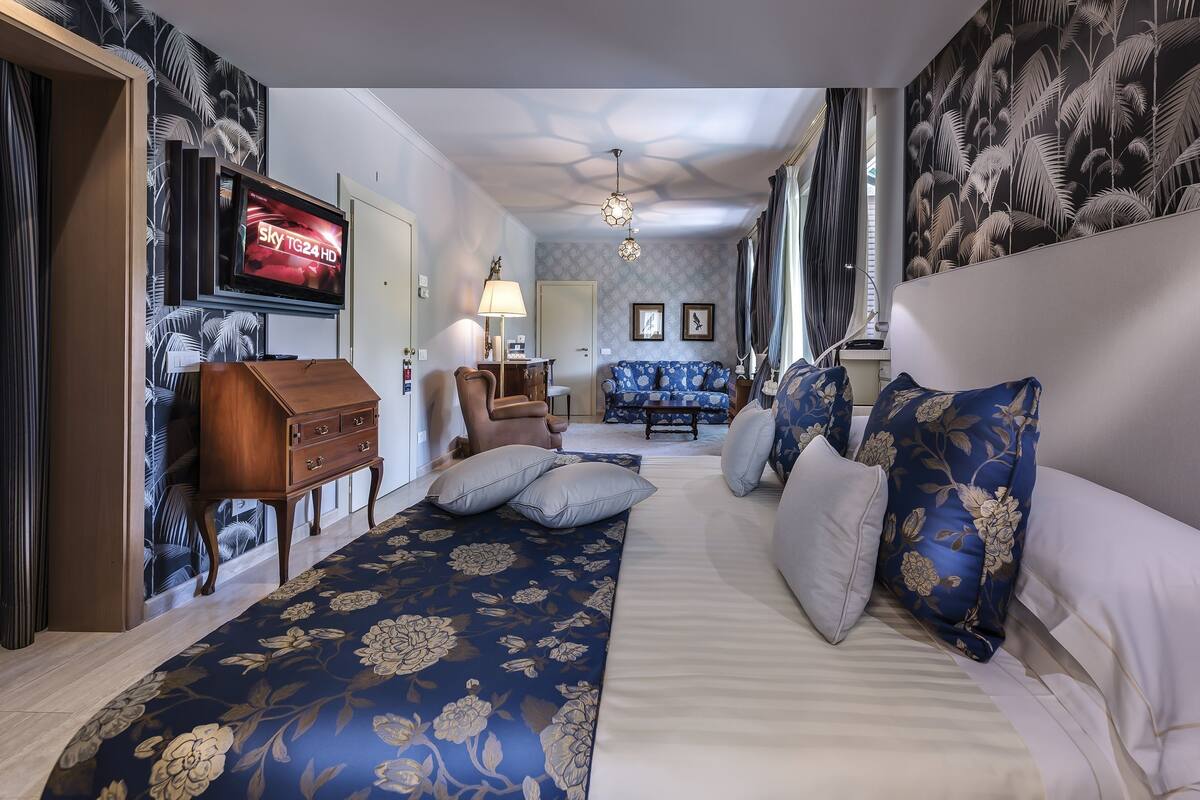 Une chambre d’hôtel avec un lit, un canapé, une télévision et un bureau.