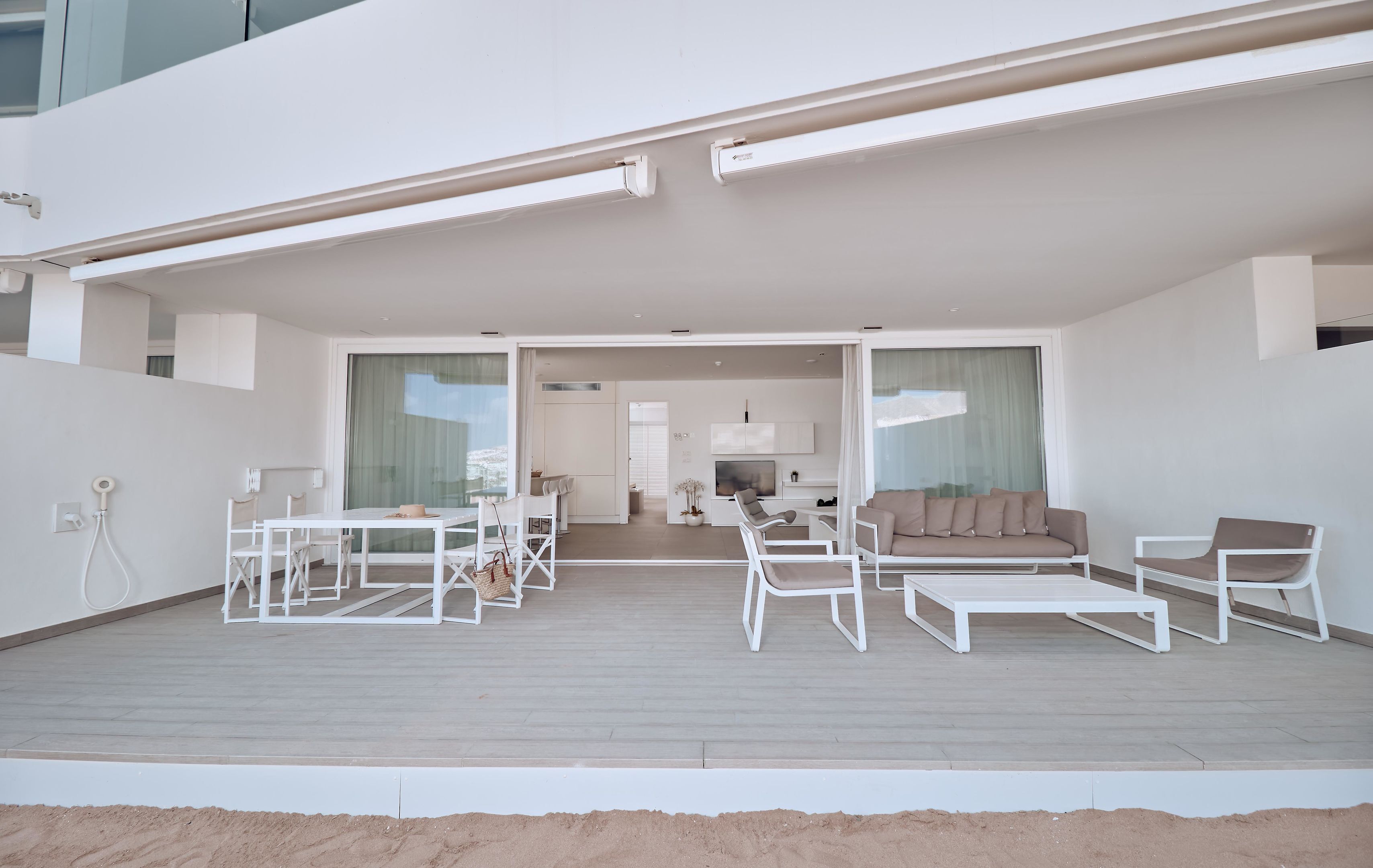 A modern living area with a sofa, chairs, and a dining table.