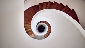 Una escalera de caracol con peldaños de madera y una pared blanca.