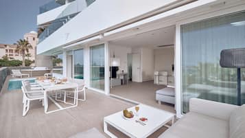 Una zona esterna moderna con piscina, tavolo da pranzo e posti a sedere.