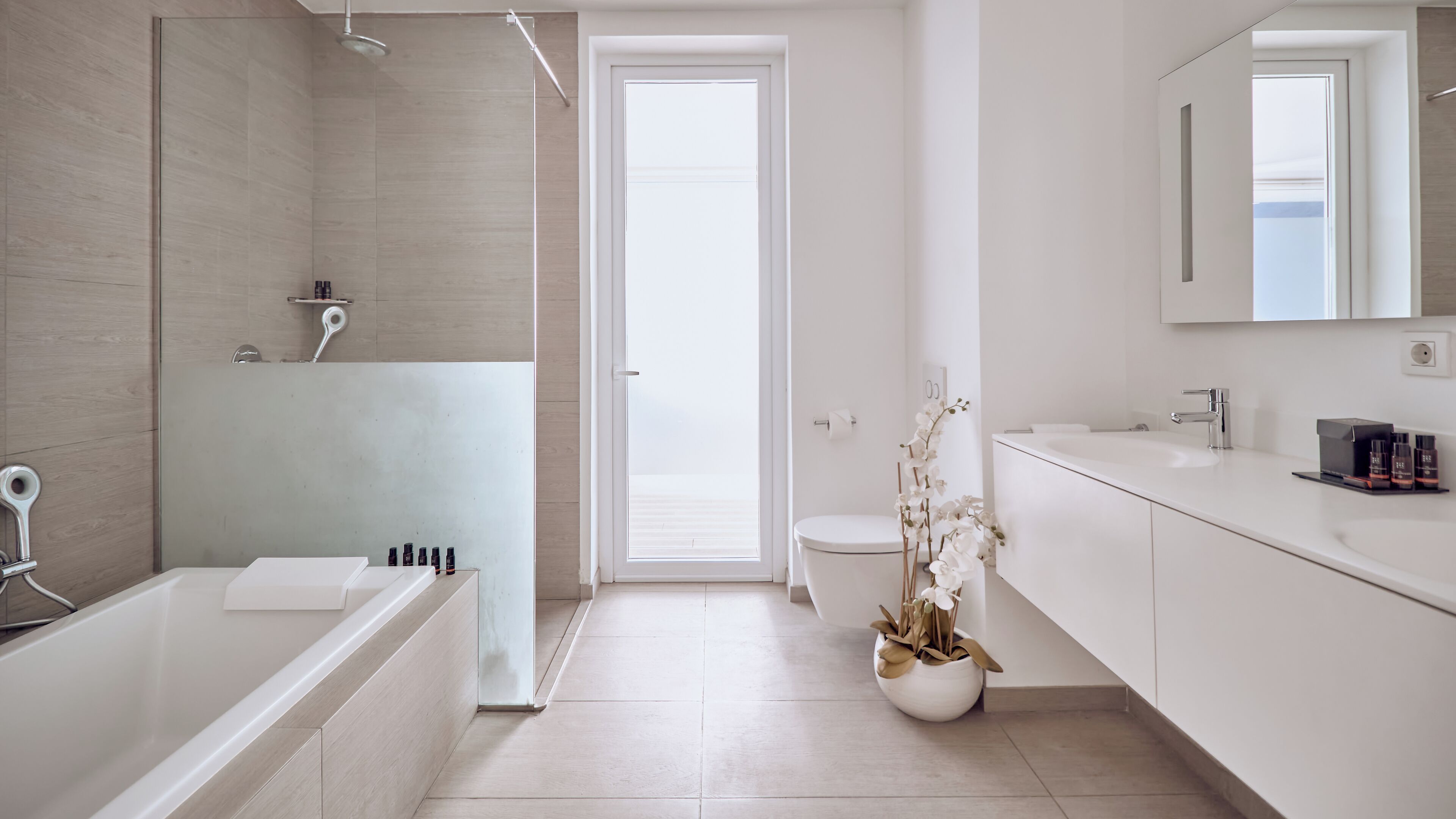 Un baño moderno con bañera, ducha, inodoro y lavamanos.