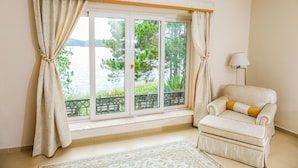 A room with a large window, a chair, and a lamp. - Binh An Village Dalat (Xuan Huong - Da Lat)