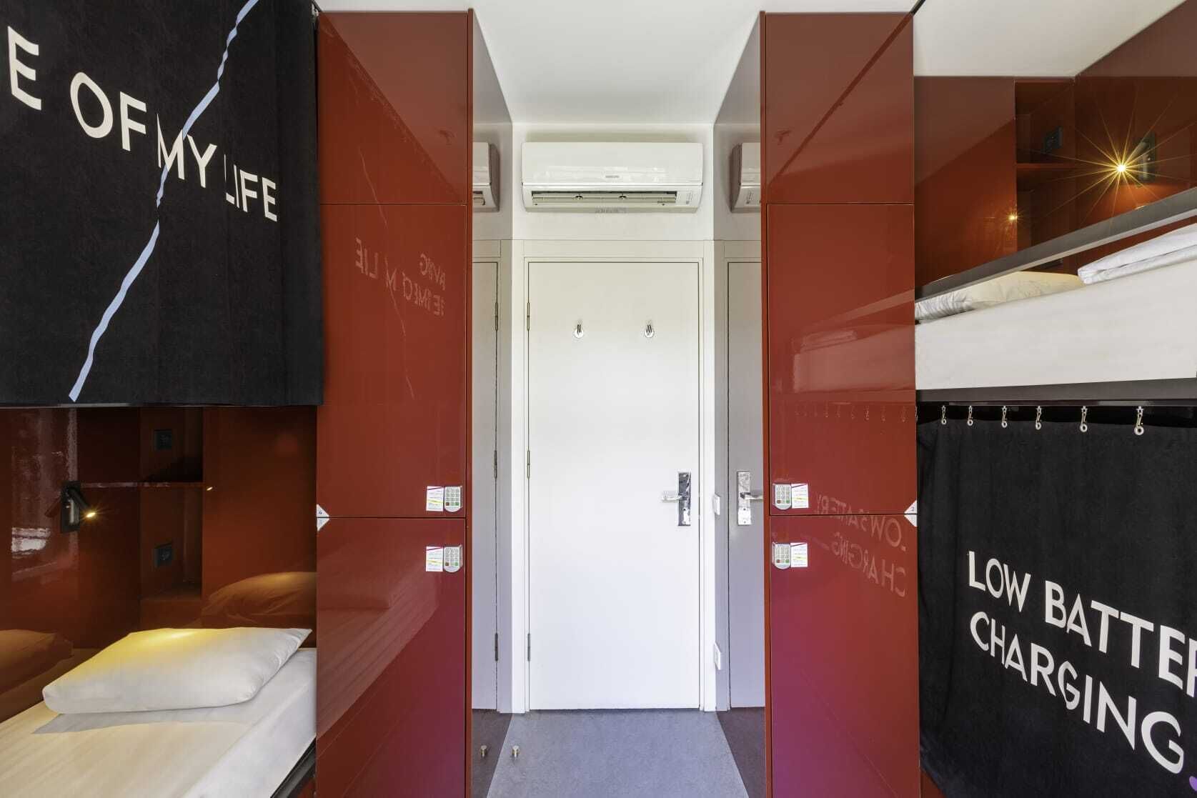 Une chambre d’hôtel avec un lit, une porte et un porte-serviettes sur lequel est accrochée une serviette.