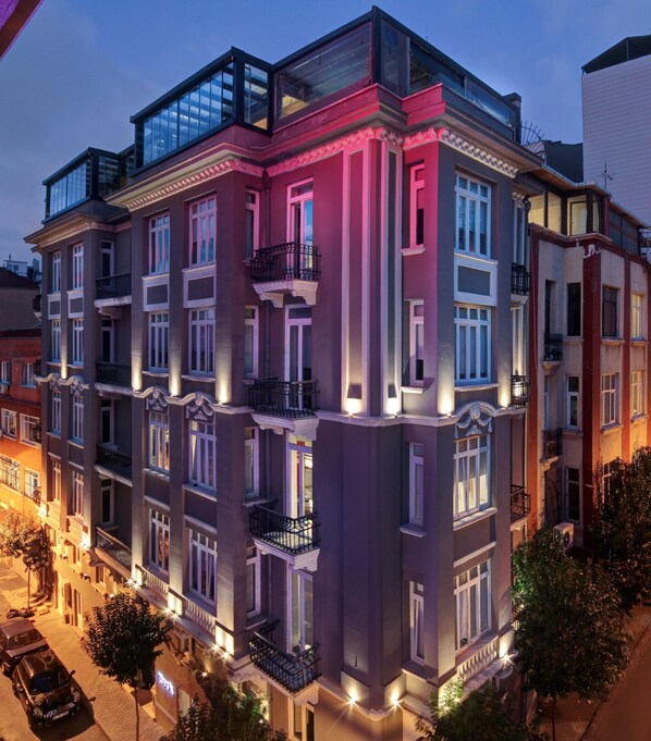 A multi-story building with balconies and large windows, featuring a modern architectural style.