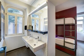 A bathroom with a sink, mirror, and window.