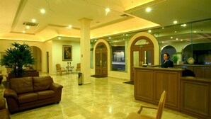 A lobby with a reception desk, seating area, and a large plant. - Best Western Centro Cadereyta (Cadereyta Jimenez)