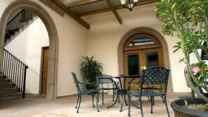 A covered patio with a table and chairs, a staircase, and a potted plant. - Best Western Centro Cadereyta (Cadereyta Jimenez)