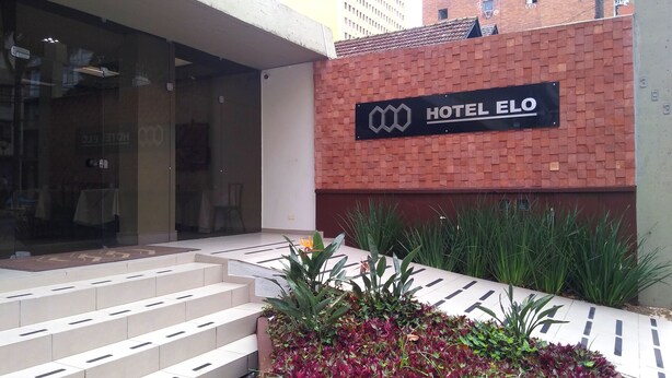 Der Eingang zum HOTEL ELO mit einer Ziegel-Fassade und einem Schild über der Tür.