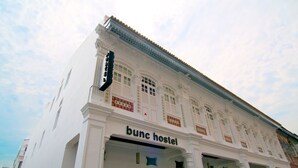 Un edificio con un cartel que dice "bunc hostel" y elementos arquitectónicos tradicionales.