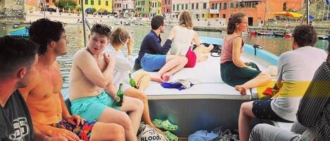 A group of people sitting on a boat with a cityscape in the background.
