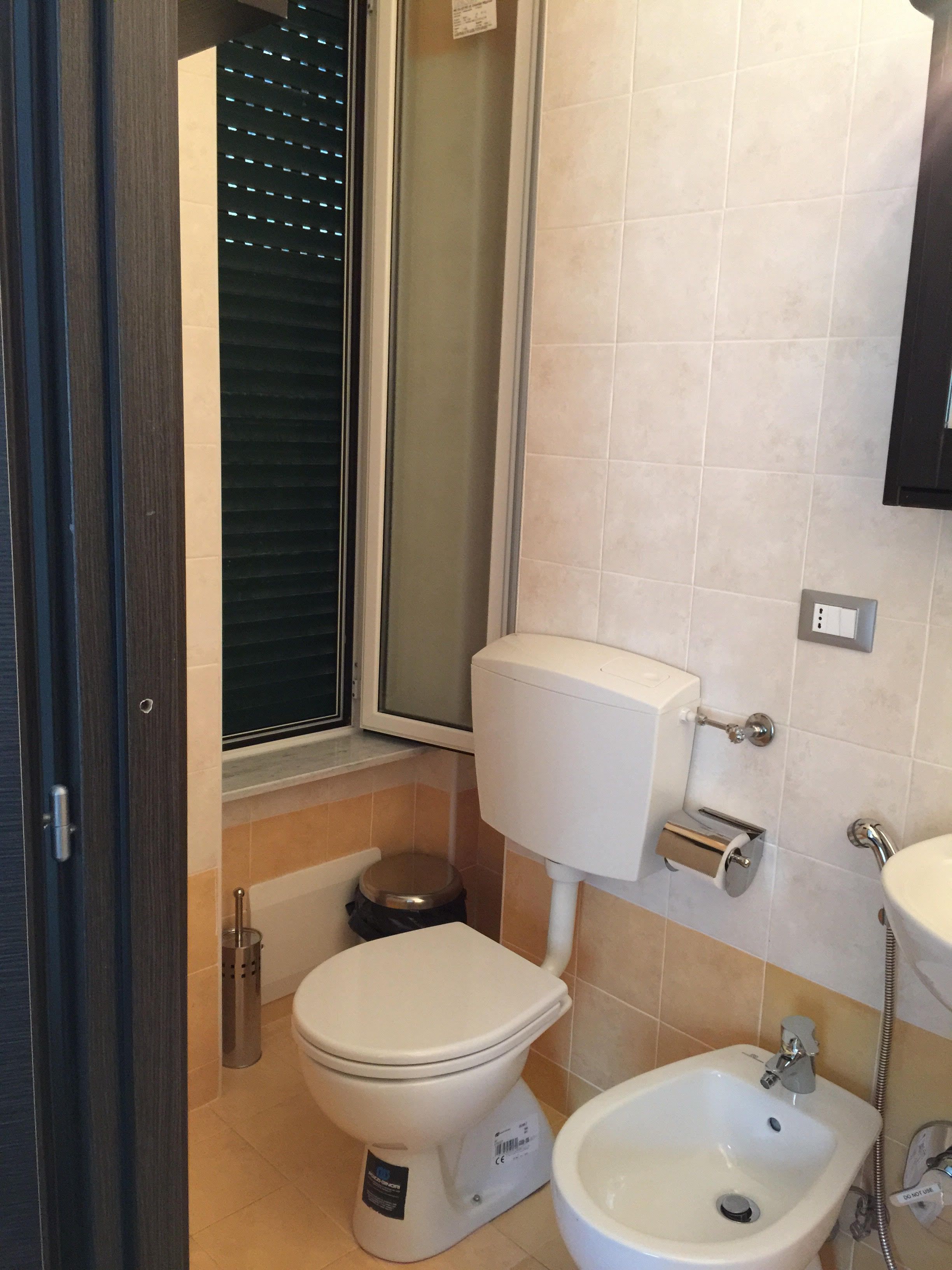 A bathroom with a toilet, bidet, and sink.