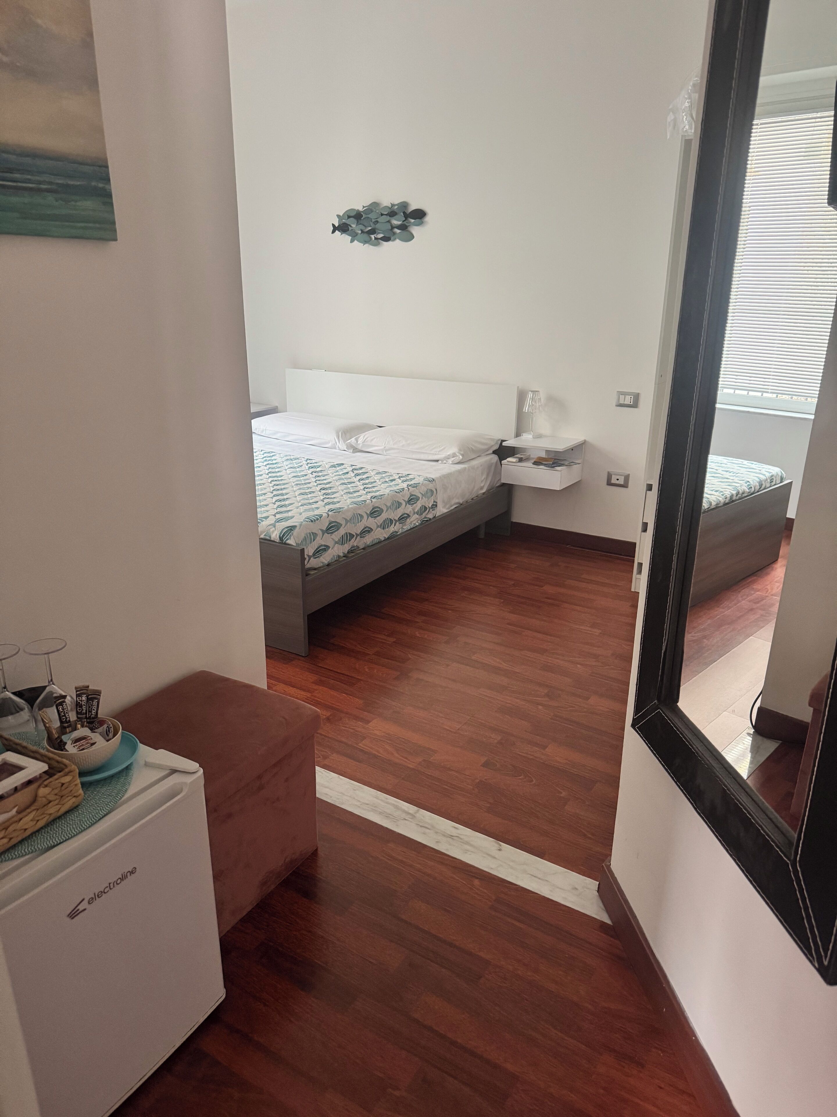 A bedroom with a bed, bedside table, and a small window.