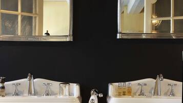 A bathroom with two white sinks, a mirror above each, and a wall-mounted light fixture.
