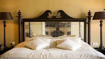 Un lit bien fait, avec une tête de lit agrémentée d’un miroir et d’éléments décoratifs.