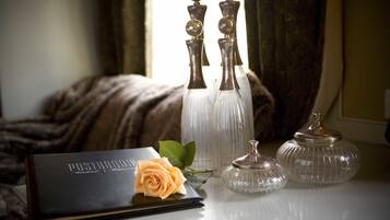 A table with a book, a rose, and three glass vases.
