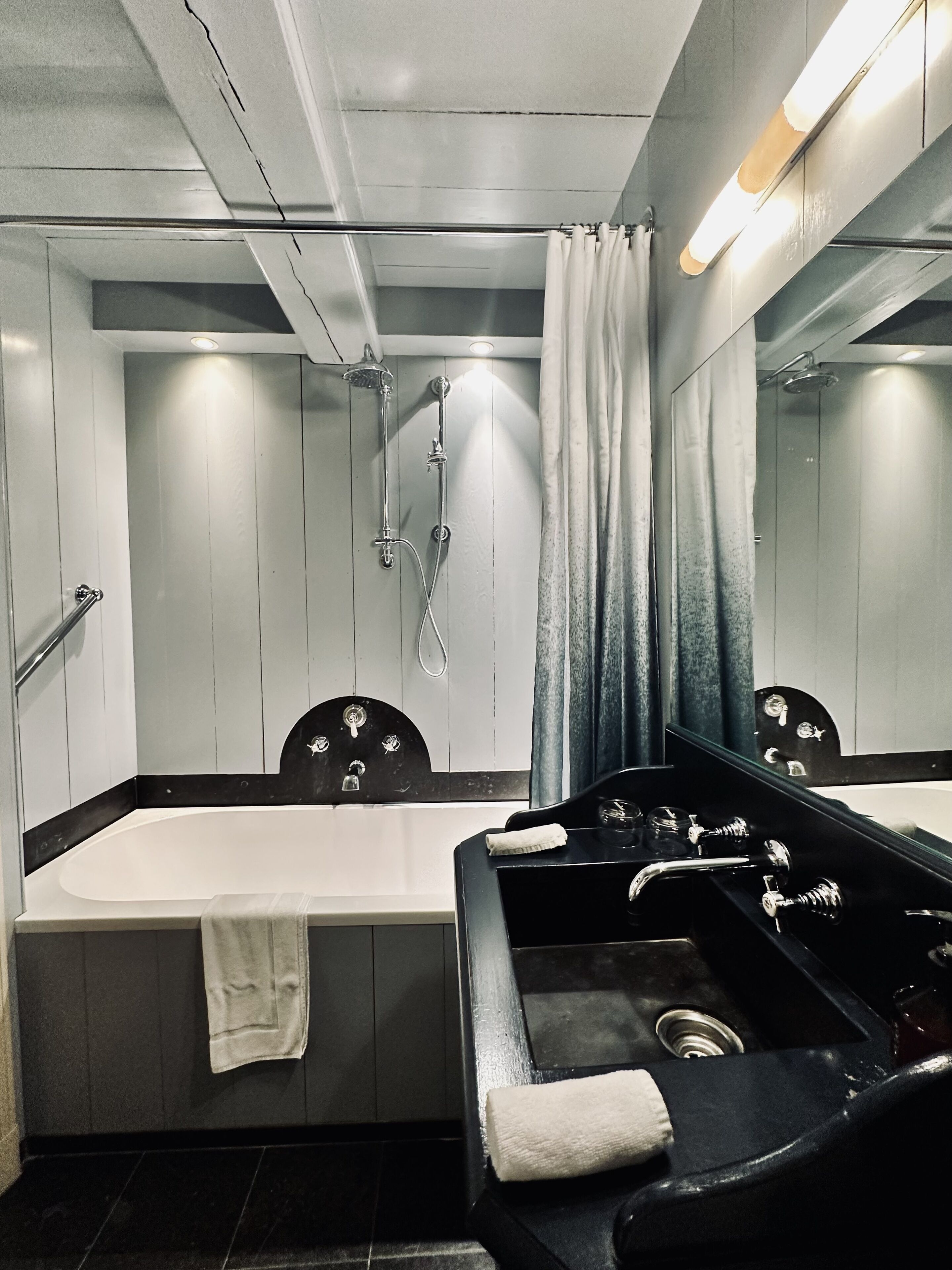 Une salle de bain moderne dotée d’une grande baignoire, d’une douche séparée et d’un meuble-lavabo avec un miroir.