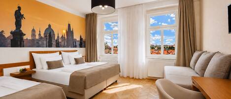 A hotel room with a bed, two bedside tables, a sofa, a chair, and a large window with curtains.