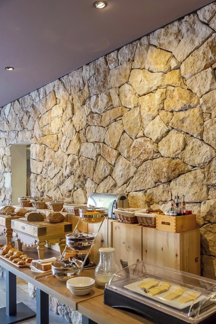 Un buffet proposant une variété de plats, avec un mur en pierre en arrière-plan.