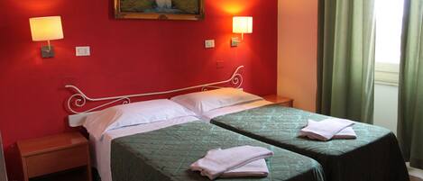 A hotel room with two beds, a nightstand, a painting on the wall, and two wall-mounted lamps.