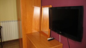A room with a wooden cabinet, a television on a stand, and a radiator. - Hotel Genzianella (Florence)
