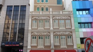 Un edificio con toldo rojo, un letrero que dice Jayleen 1918 Hotel y un letrero que anuncia Pretty Star Piano Club.