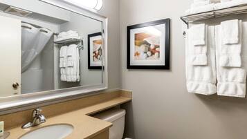 A bathroom with a sink, mirror, towel rack, and framed pictures on the wall.