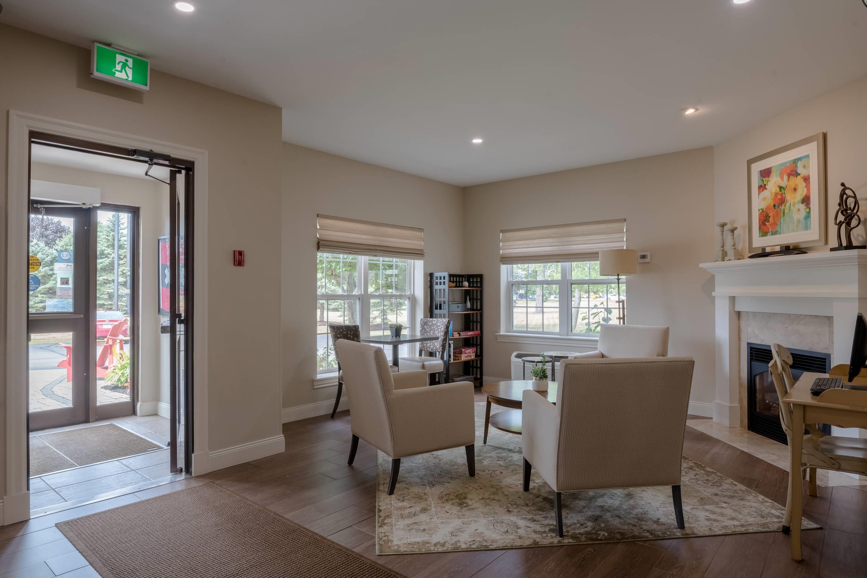 A spacious room with a fireplace, a dining area, and a seating area with chairs and a table.