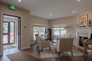 Una habitación amplia con chimenea, un comedor y una zona de estar con sillas y una mesa.