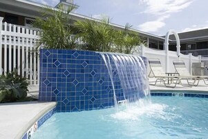 Una piscina al aire libre de temporada, sombrillas