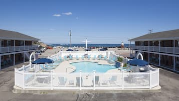 Una piscina al aire libre de temporada, sombrillas
