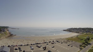 A coastal area with a beach, parking lot, and buildings. - Sands by the Sea Motel (York Beach)
