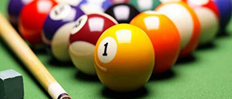 Gros plan sur des billes de billard posées sur un tapis vert.