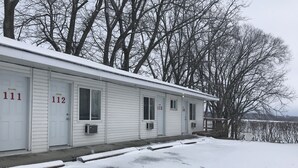 A row of motel rooms with numbers 111, 112, 113, and 114. - Bayside Motel (Quinte West)