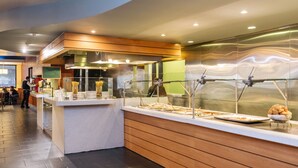 Un espace buffet au design moderne, comprenant un comptoir où sont présentés divers plats et une vitrine réfrigérée.