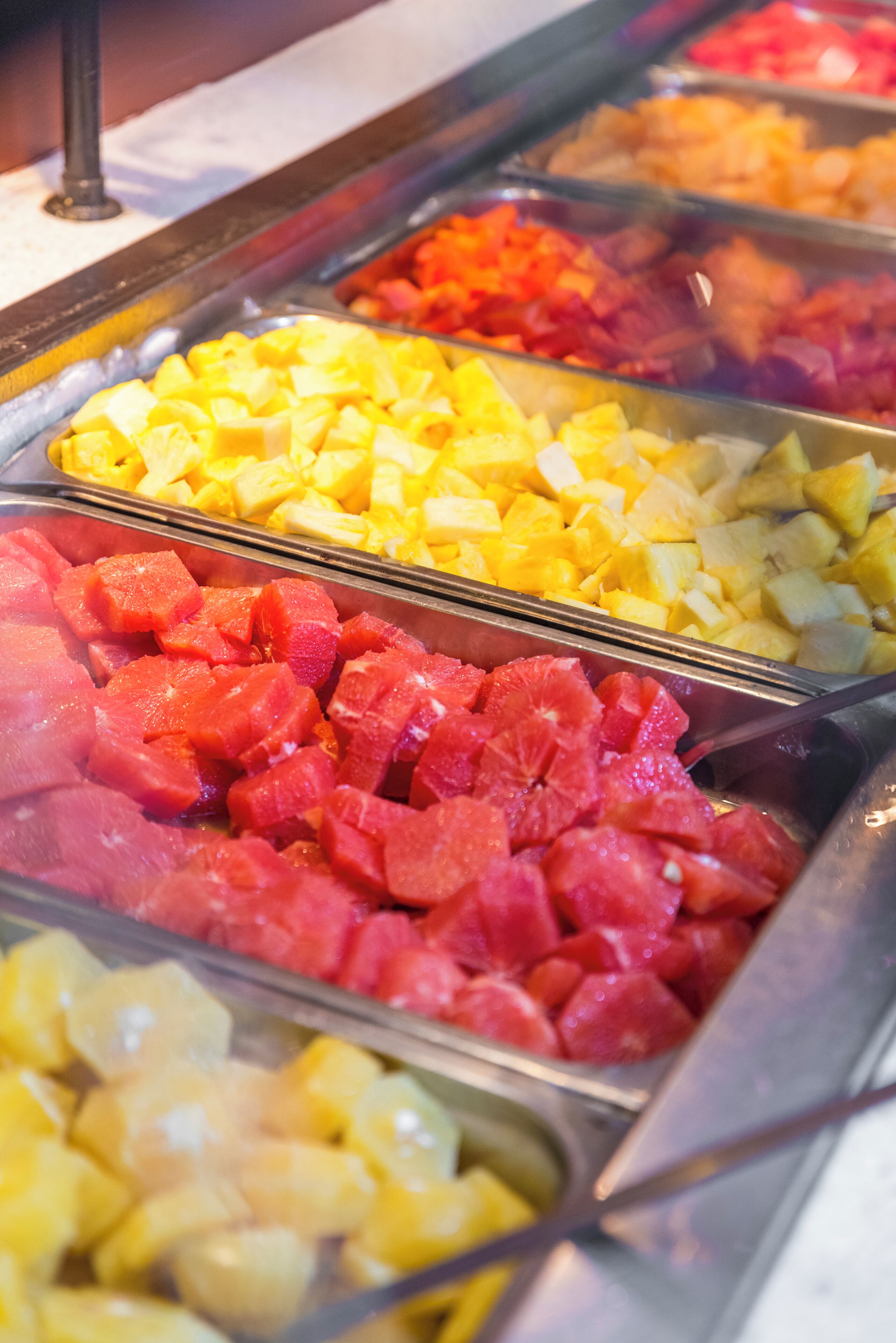 A buffet with various fruits including pineapple, watermelon, and mango.