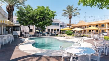 Una piscina al aire libre, sillones reclinables de piscina