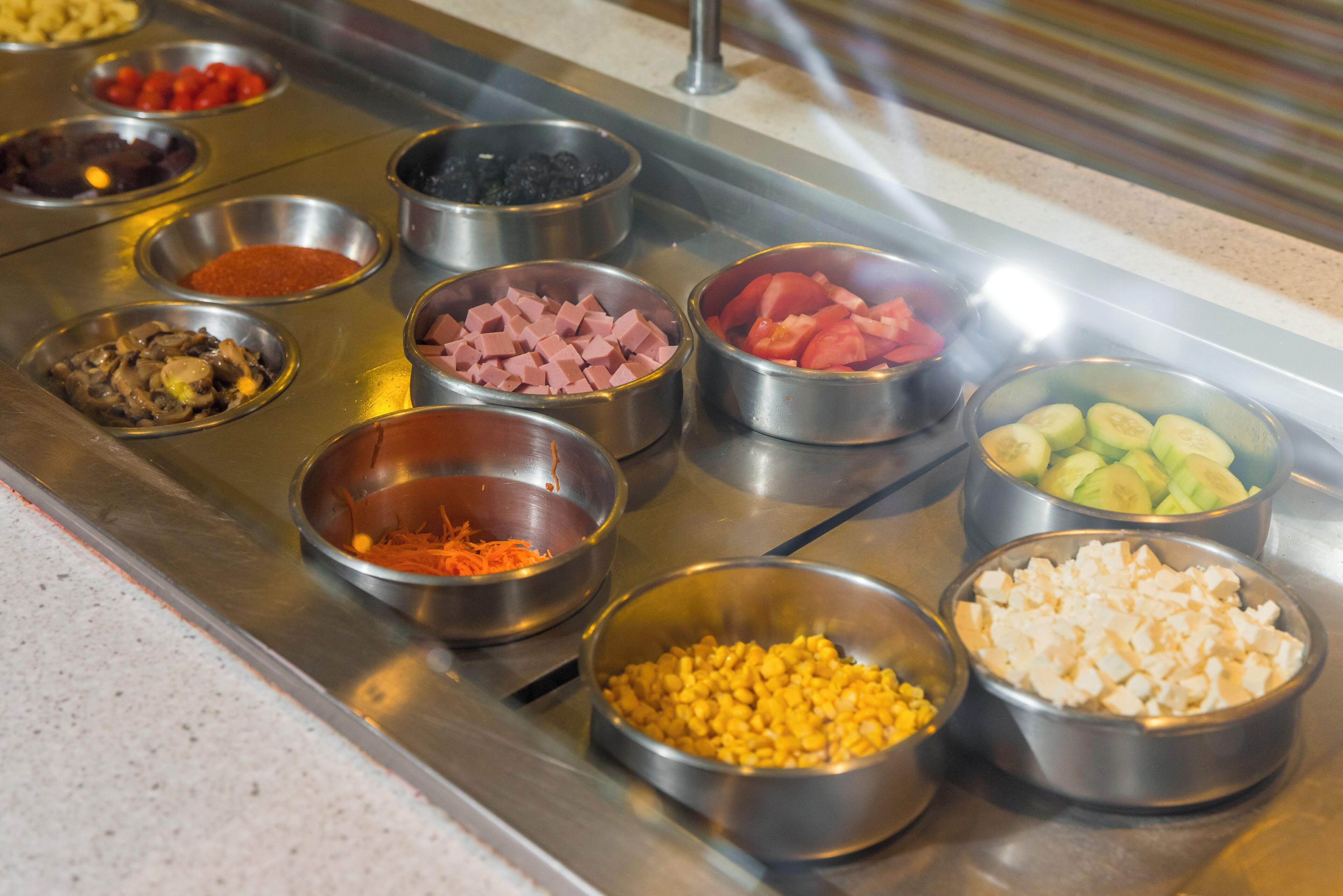 En buffet med forskellige retter i metalfade.