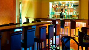 A bar area with bar stools and a bartender. - Classic Sarovar Portico Thiruvananthapuram (Thiruvananthapuram)