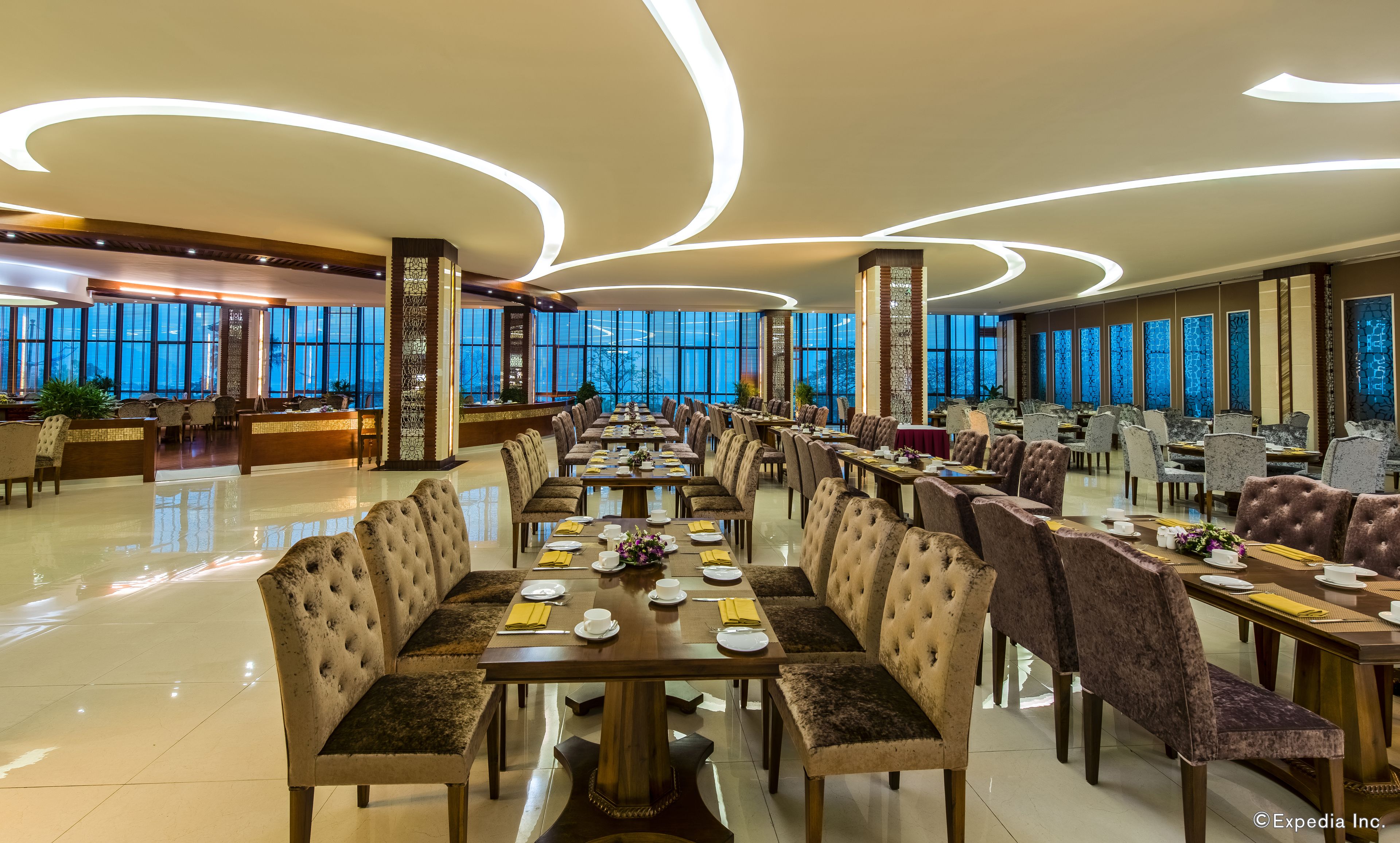 Un comedor amplio con decoración moderna, ventanas grandes y un suelo limpio y pulido.
