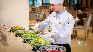 Un buffet proposant divers plats, notamment des salades et un saladier de fruits.