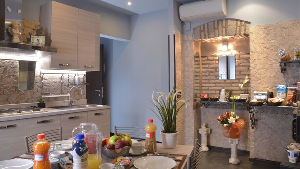 A modern kitchen with a stone accent wall, a built-in oven, and a breakfast bar. - B&B La Casa di Patty (Rome)