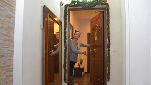 A hallway with a wooden door and a mirror reflecting the door. - B&B La Casa di Patty (Rome)