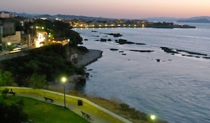A coastal area with a paved walkway, benches, and street lamps. - Villa Andromeda (Chania)