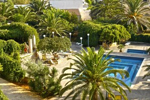 Een buitenzwembad, parasols bij het zwembad en ligstoelen