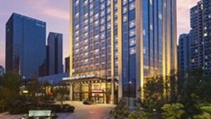 Et højt hotelhus med moderne design, kendetegnet ved en markant indgang og mange etager.