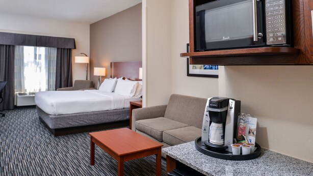 A hotel room with a bed, a sofa, a coffee maker, and a microwave. - Holiday Inn Express & Suites York by IHG (York)
