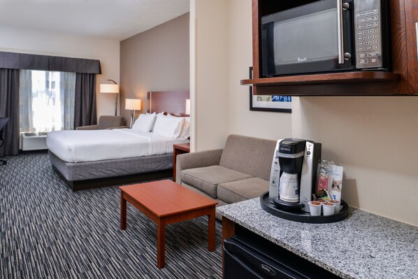 A hotel room with a bed, a sofa, a coffee maker, and a microwave. - Holiday Inn Express & Suites York by IHG (York)