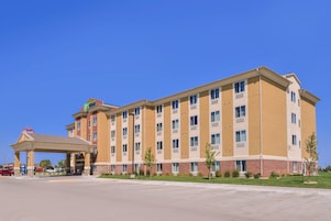 Hotel com vários andares, entrada coberta e estacionamento.